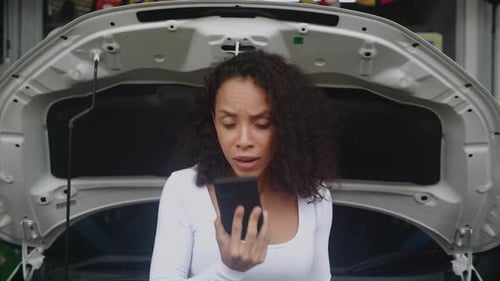 Woman Talks on Phone in Front of Car
