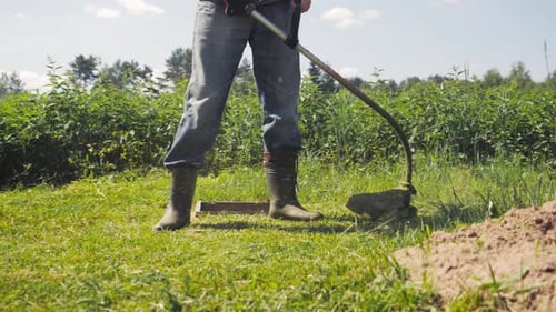 Male Gardener Mowing Green Lawn with Manual Gas Grass Mower Garden Maintenance