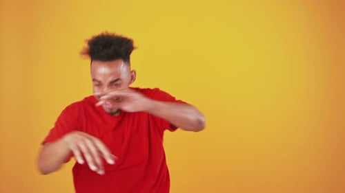 Happy Black Guy Enjoying Great Music Dancing Over Orange Background