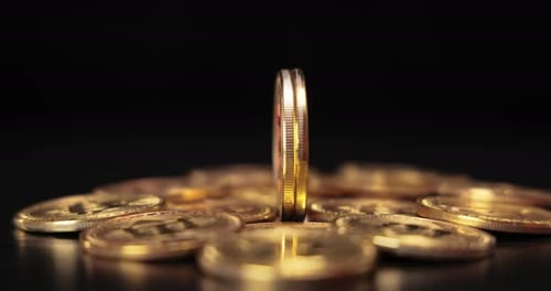 Gold Bitcoin Coins Rotating on Dark Surface