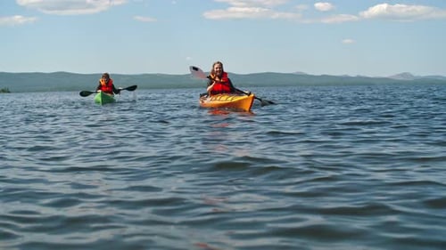 Kayakers Paddling across a Lake on Sunny Day