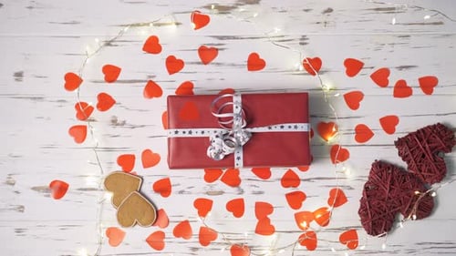 Female Hand Taking a Gift Box From the Desk Topdown View