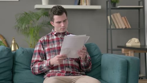 Young Adult Reading Papers in Home Setting