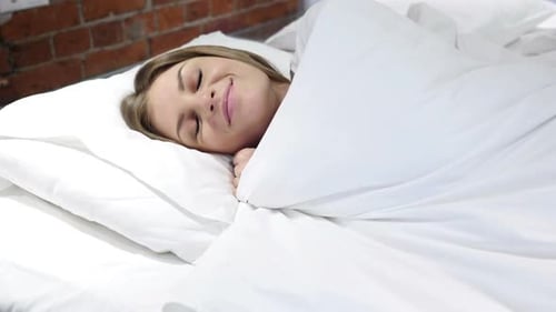 Woman Sleeping Peacefully in White Bed, Close Up