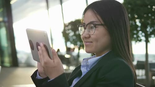 Female in Business Suit Searching the Web on Tablet Device