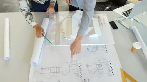 Designers Collaborate on Architectural Blueprints and Model