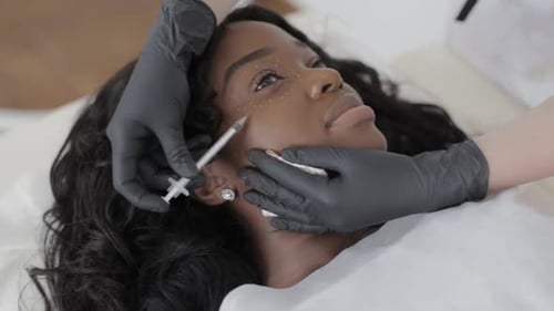 Close Up of Hands of Doctor Cosmetologist Making the Rejuvenating Facial Injections Procedure for