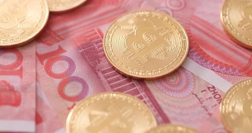 Bitcoin coins and Chinese Yuan Currency Close Up