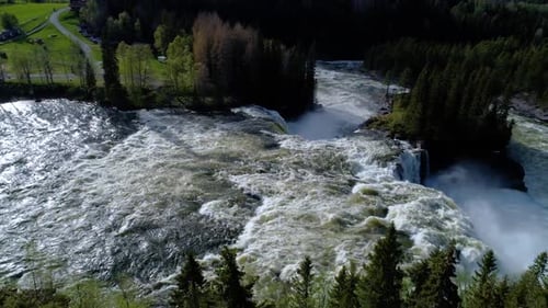Majestic Waterfall Flowing Through Verdant Forest Landscape