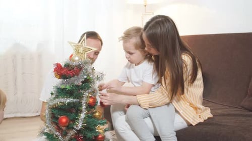 Family Decorating Christmas Tree in Home Interior