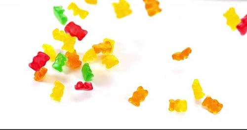 Colorful Gummy Bears Falling on White Background