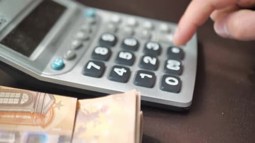Mão masculina conta despesas ou receitas em uma calculadora