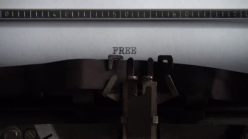 Typing word Free on retro typewriter. Close up.
