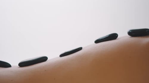 Adult Receiving Hot Stone Massage in Spa