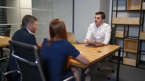 Família com corretor de imóveis na sala de reuniões discutindo sobre contrato de compra de casa.