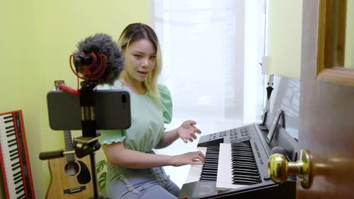 Woman Recording Music on Keyboard with Cellphone