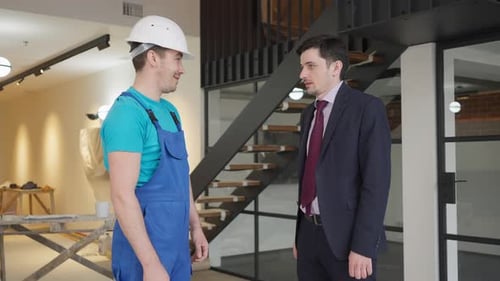 Side View of Positive Confident Successful Businessman and Builder Shaking Hands Standing in New