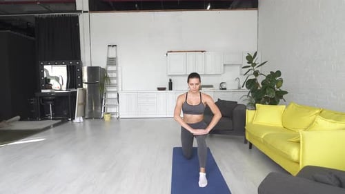 Beautiful Young Woman Does Exercises for the Abdomen on the Mat in the Room