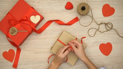 Wrapping Red Ribbon on a Valentines Gift