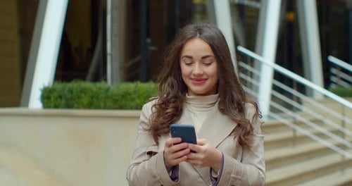 Attractive Young Woman Using Phone in the City Center. Chatting with Friends, Girl Using Cellphone