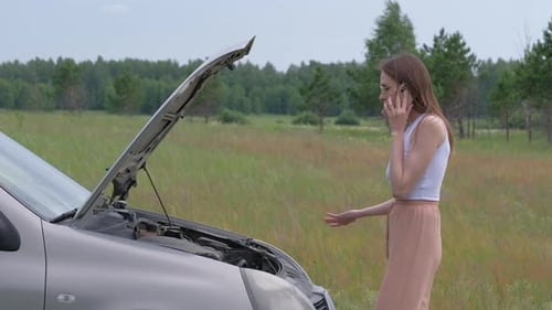 Woman Talking on Cellphone with Car Trouble