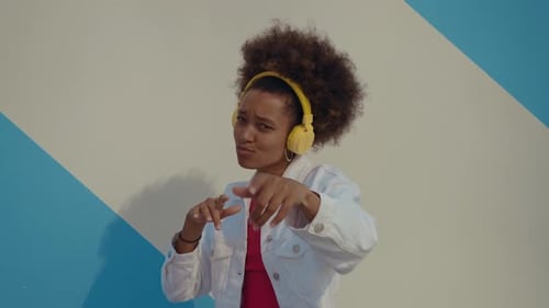 Expressive Woman Dances with Headphones in Urban Setting