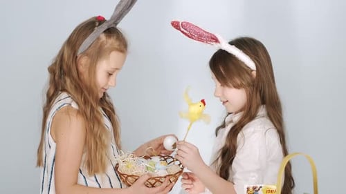 Two Girls Friends in Bunny Ears Holding Easter Eggs on Holiday