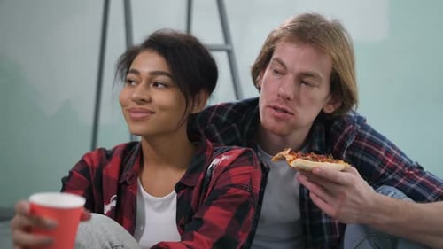 Young Couple Taking a Pizza Break Indoors