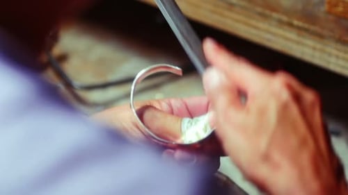 Artisan Hand Filing Silver Bracelet in Workshop