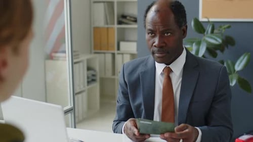 Man Reviews Passport in Office Setting