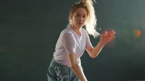 Dynamic Woman Dances in a Dark Studio