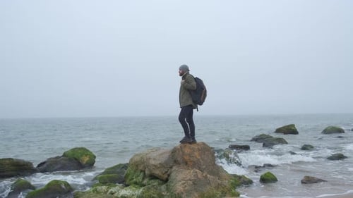 Ein einsamer Tourist in der Wildnis mit Stone Mountains und Küste