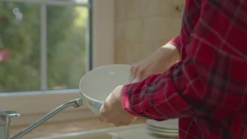 Close Up of Female Hands Washing Dish By the Window