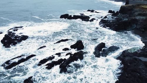 Ocean Coast in Iceland Waves Break on Rocks The Sea Erodes Volcanic Rocks Aerial View