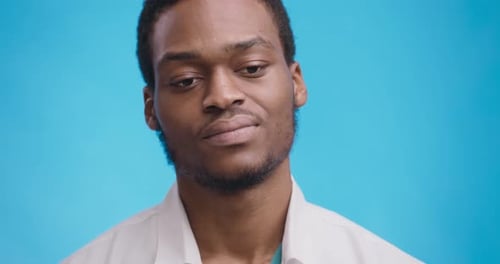Studio Portrait of Young African American Man Doubting, Thinking of Idea or Worried About Something