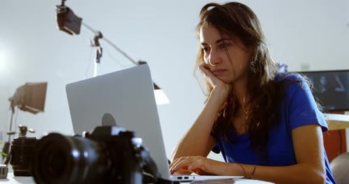Woman Working on Laptop in Photographer's Studio