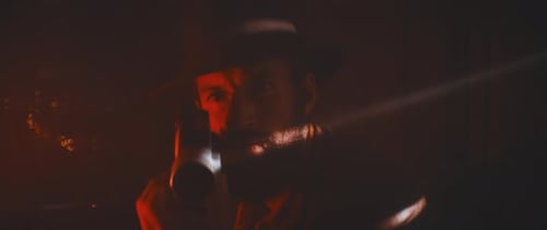 Man Playing Harmonica in Dark Red Room