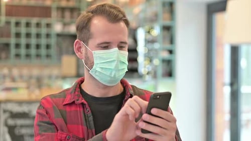 Adult Using Smartphone and Wearing Face Mask