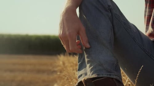 Farmer Relaxing on Hay Bale in Golden Field