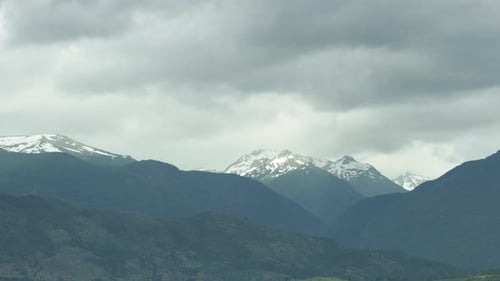 Breathtaking Scenery of Clouds Rolling Above Mountain Peak