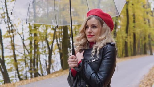 Blonde Woman Holding Umbrella in Autumn Park