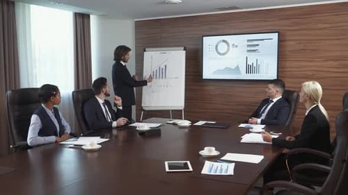 Reunión de negocios, un joven empresario habla en una reunión y muestra una infografía financiera en el