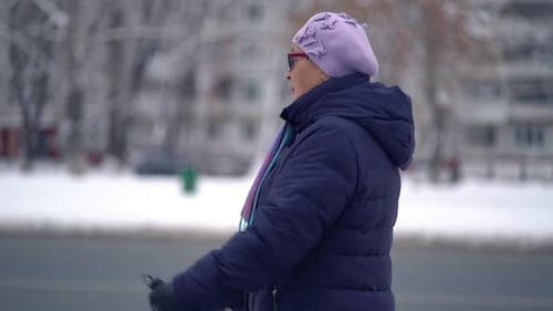 Senior Woman Nordic Walking in Winter City