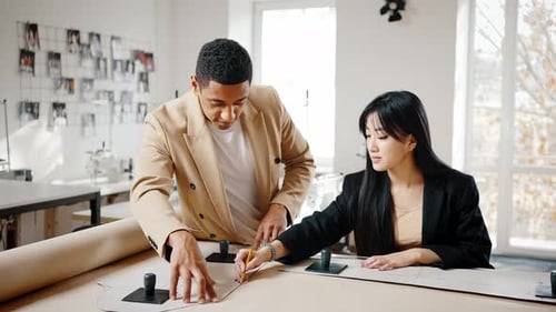 Couple of Multiethnic Fashion Designers Creating New Clothes Collection Together Drawing Pattern on