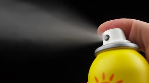 Finger Presses Nozzle on Yellow Spray Can