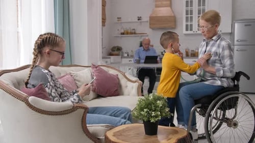 Caring Boy Listening to Grandmother's Heart with Toy Stethoscope
