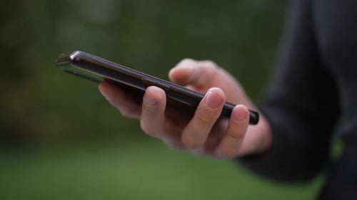 Hand Scrolling on Phone Technology Close Up