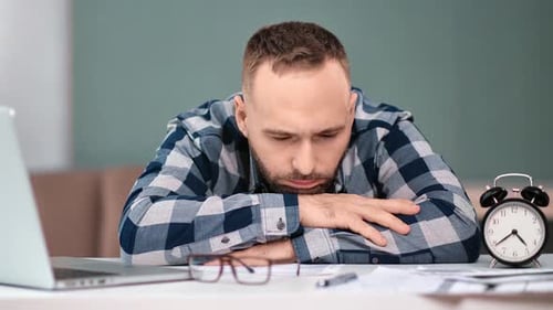 Homme déprimé souffrant de bourreau de travail allongé sur la table au travail
