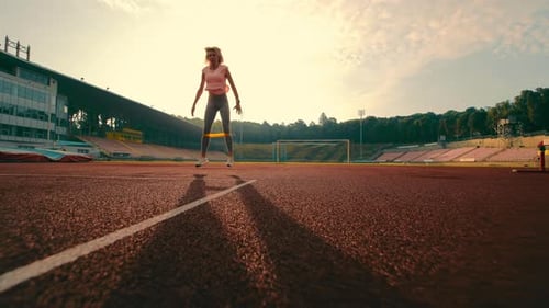 Silhouette of a Female Athlete Who Trains on the Sports Field