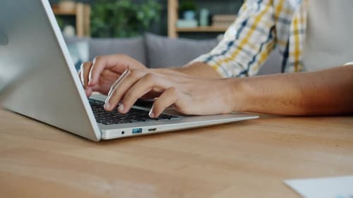 Close-up of Male Hands African American Man Working with Laptop Typing at Home